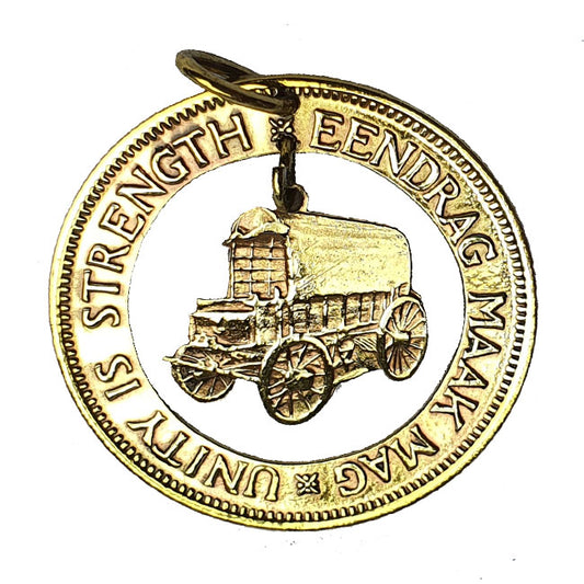A gold-colored pendant featuring a historical image of a wagon and the engraved text 'EENDRACH MAK' along with 'STRENGTH IS IN THE HARNESS'.