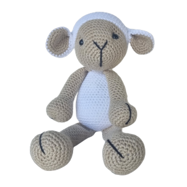 A beige and white crochet toy in the shape of a sheep, with black eyes and a smiling mouth.