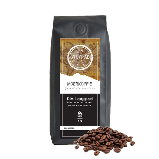A pack of Die Langpad Moerkoffie coffee beans with a medium roast label, indicating a strong body and caramel flavors. The beans are displayed in front of the packaging.