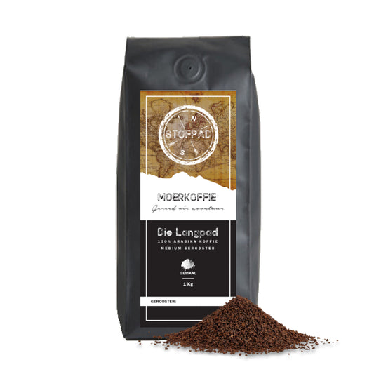 A bag of Die Langpad Moerkoffie (Ground Coffee) with a black label and a small pile of ground coffee beans in front of it, on a white background.