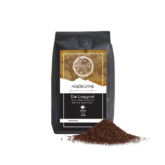 A bag of Die Langpad Moerkoffie (Ground Coffee) with a black label and a small pile of ground coffee beans in front of it, on a white background.
